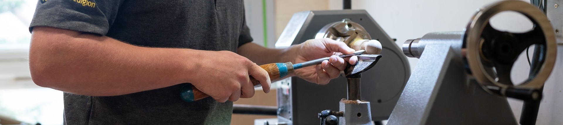 Student working on piece of furniture at machine 