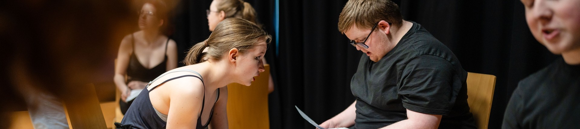 Two students sitting and running lines from script