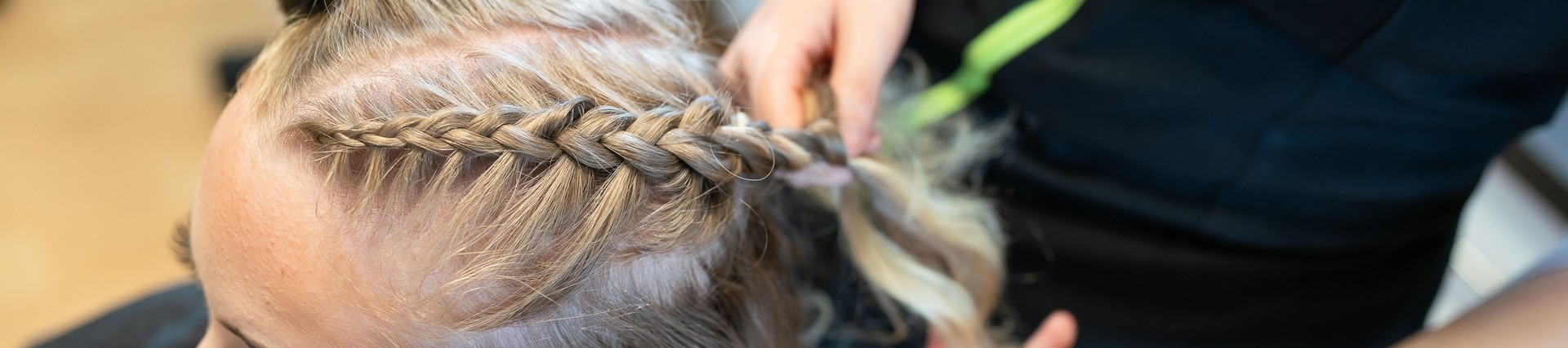 student doing french braid on client