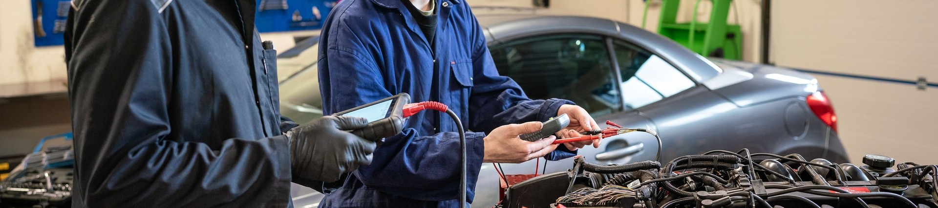 Two automotive students working on car engine