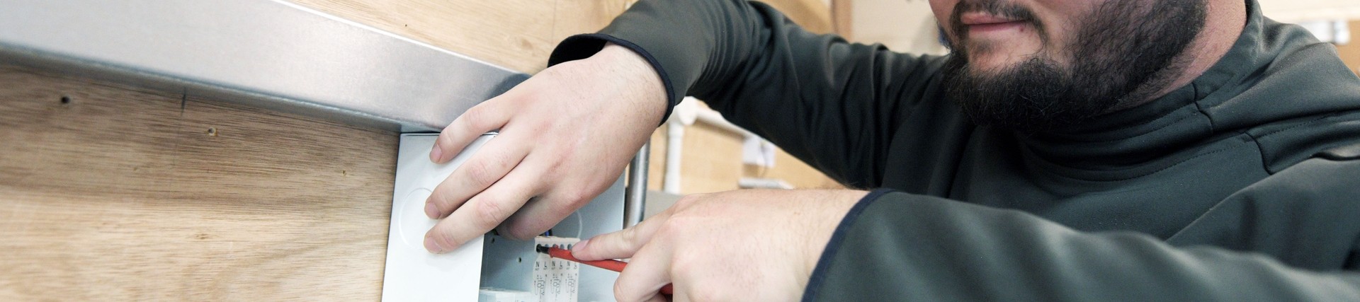 A student wires an electrical box.