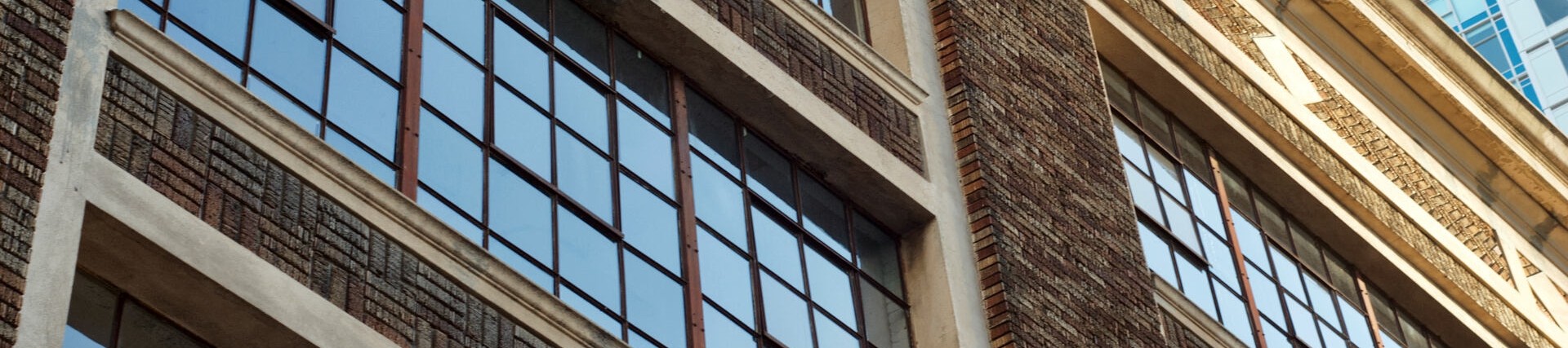 Exterior of building showing windows reflecting a clear blue sky