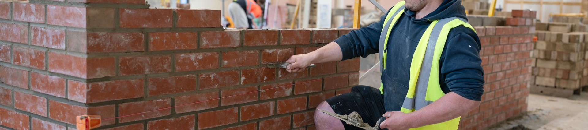 Student laying bricks in workshop