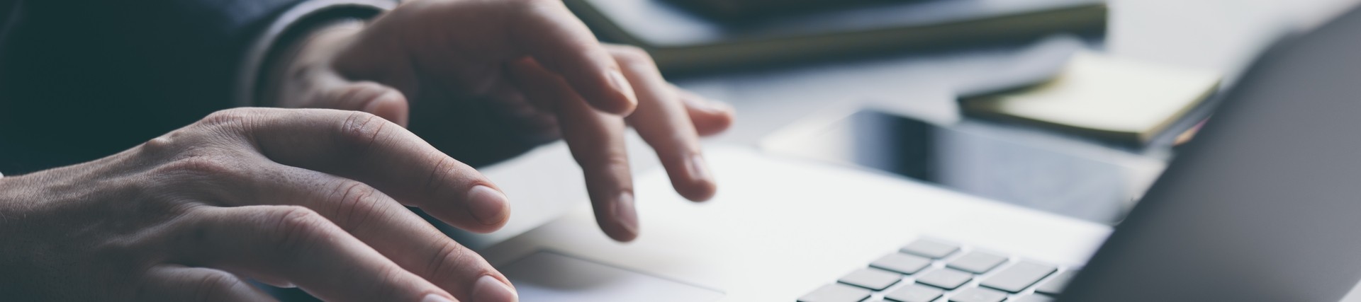 Hands of an unseen person using a laptop
