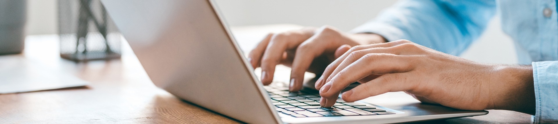 Hands of an unseen person using a laptop