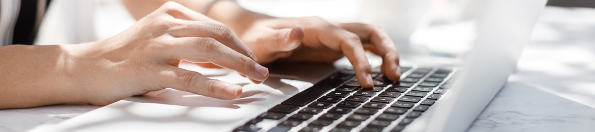 Hands of an unseen person using a laptop