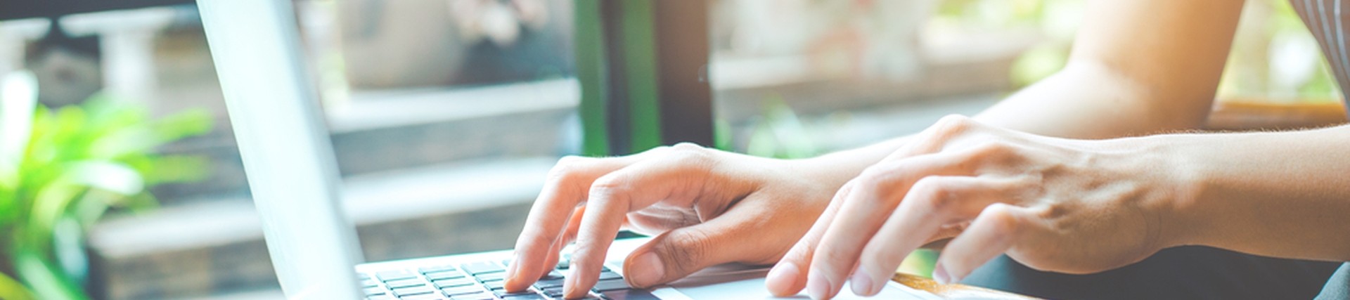 Hands of an unseen person using a laptop
