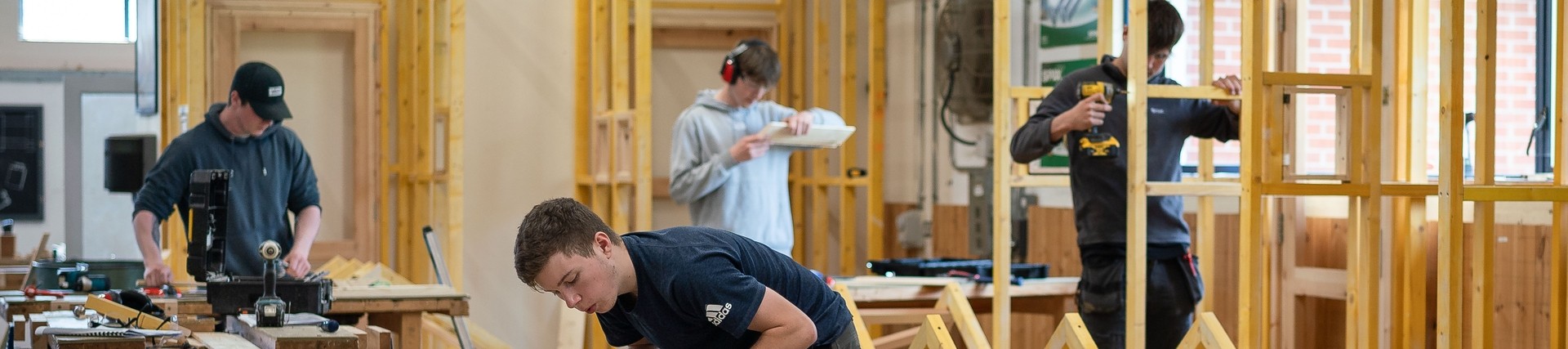 a group of students practicing site carpentry in a workshop