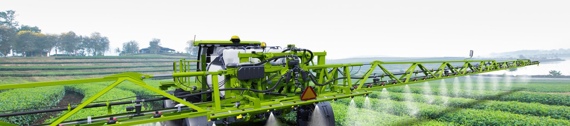 Tractor spreading pesticides on a crop field