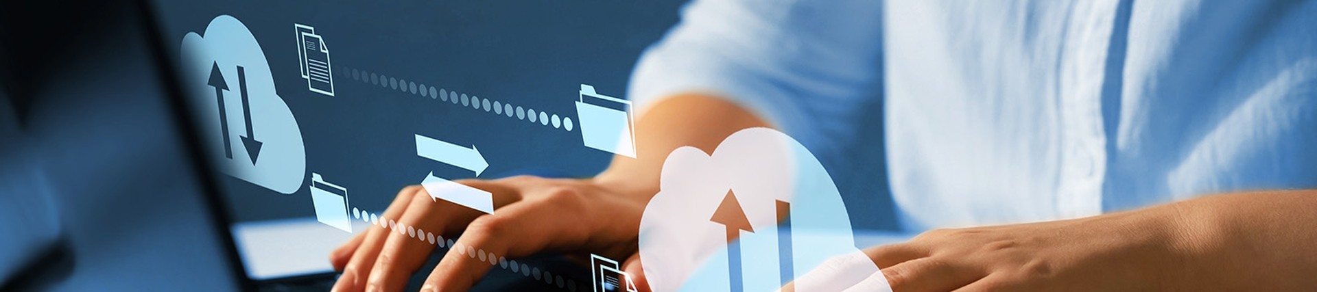 Hands of unseen person in a light blue shirt using a laptop. Above the hands, there are cloud sharing icons floating above the hands