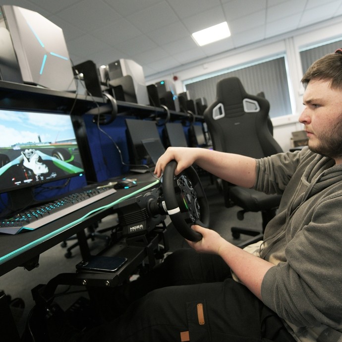 Student playing a racing game in the e-sports suite.