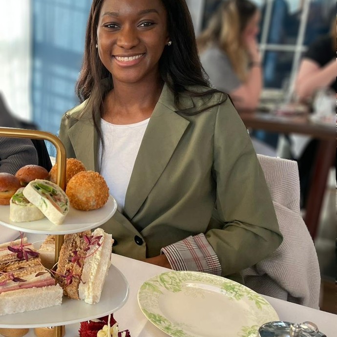 Elizabeth sitting at a table with afternoon tea
