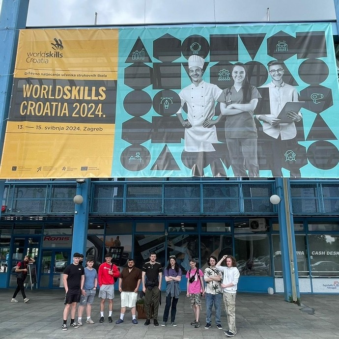 Students under the WorldSkills banner outside the building