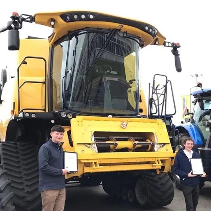 Students with their certificates by a state of the art piece of machinery