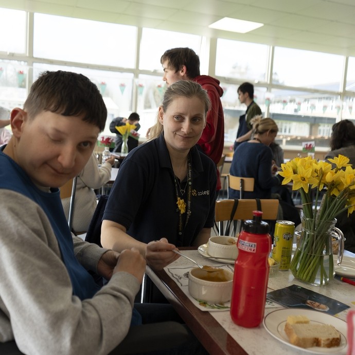 A student looks at the camera from a food table