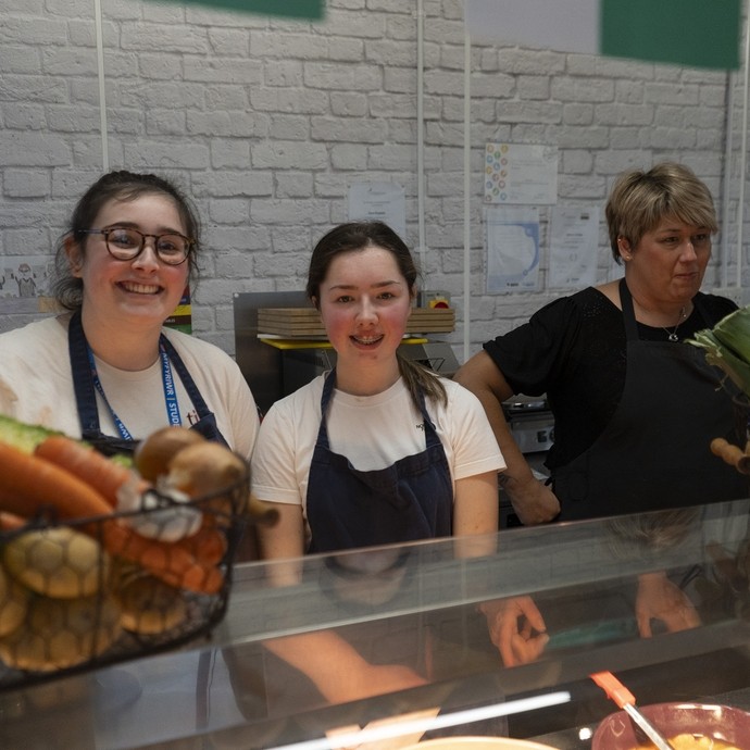 Students standing behind a serving counter