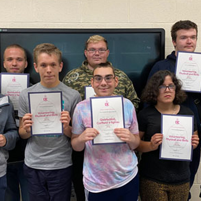 Students in a row with their certificates
