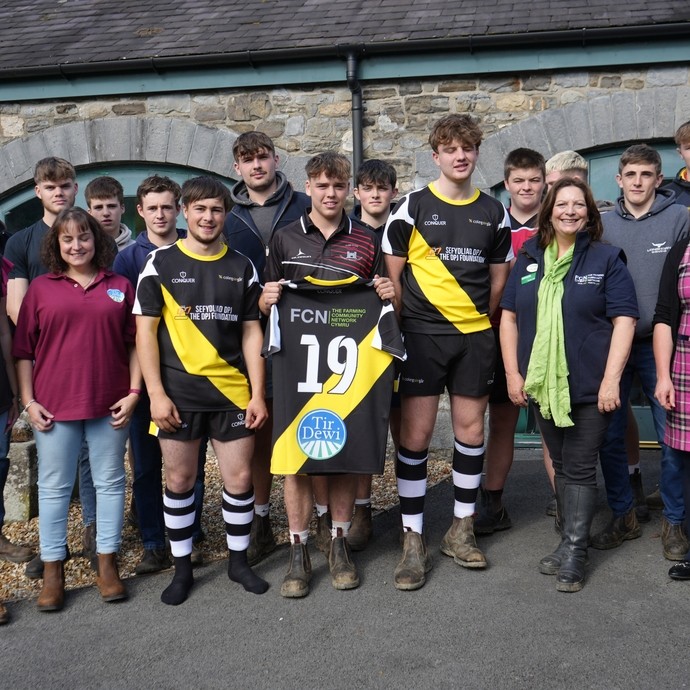 A group outside including students, charity reps and rugby squad