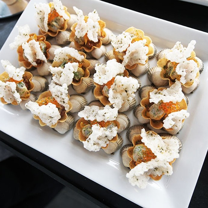 A close up of a plate of canapes with cockle shells