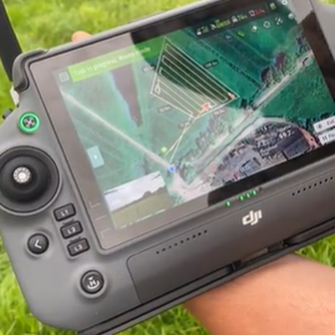 The remote control of the drone with grass as a background