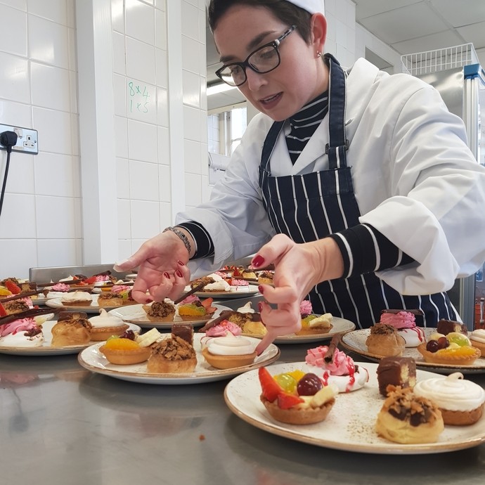 Alex Huggett learning culinary skills putting food on plates