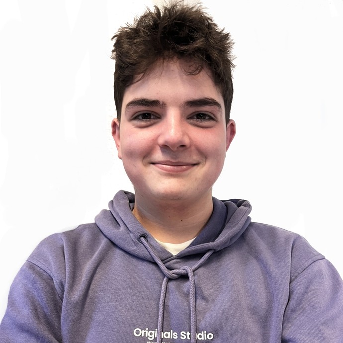 Gwion in a purple hoodie smiling at the camera