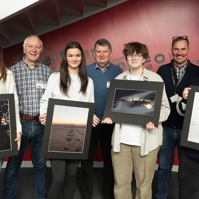 Winning students holding up their artwork with lecturer Simon and two people from the photo society