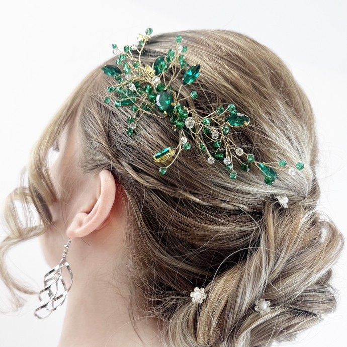 a model's hair showing hair up with a green sparkly accessory