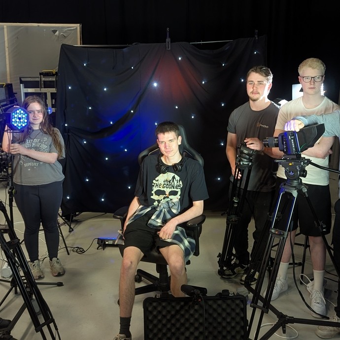 A group of students next to various apparatus in the college media studio