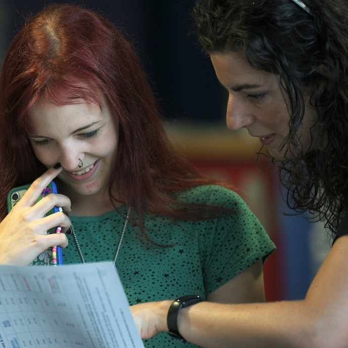 A student looking at her results happily with a lecturer guiding her through them
