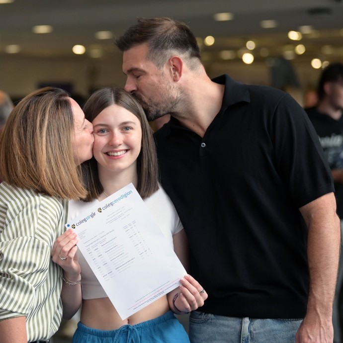 Lily with her mum and dad kissing her head