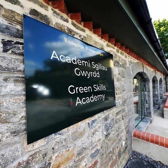 the outside of the arches building, a grey stone building with a green sign that says Green Skills Academy.