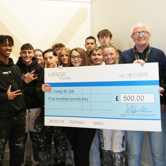 A group of students with their lecturer and reps from Valspar Trade holding an oversized cheque