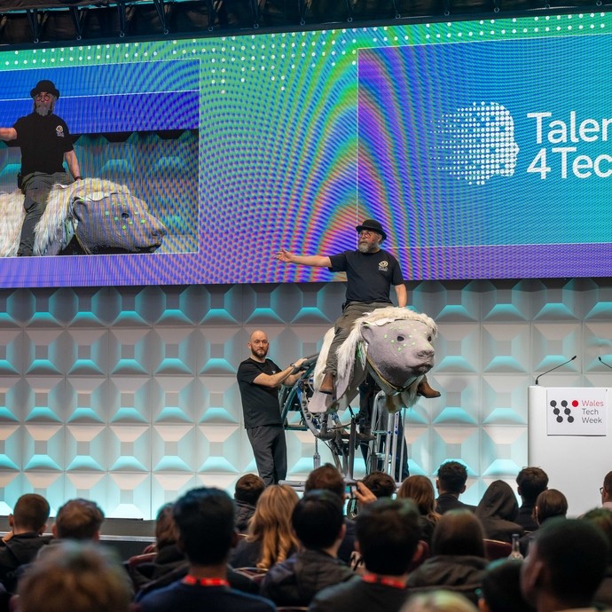A stage with a man on an animatronic talking to an audience