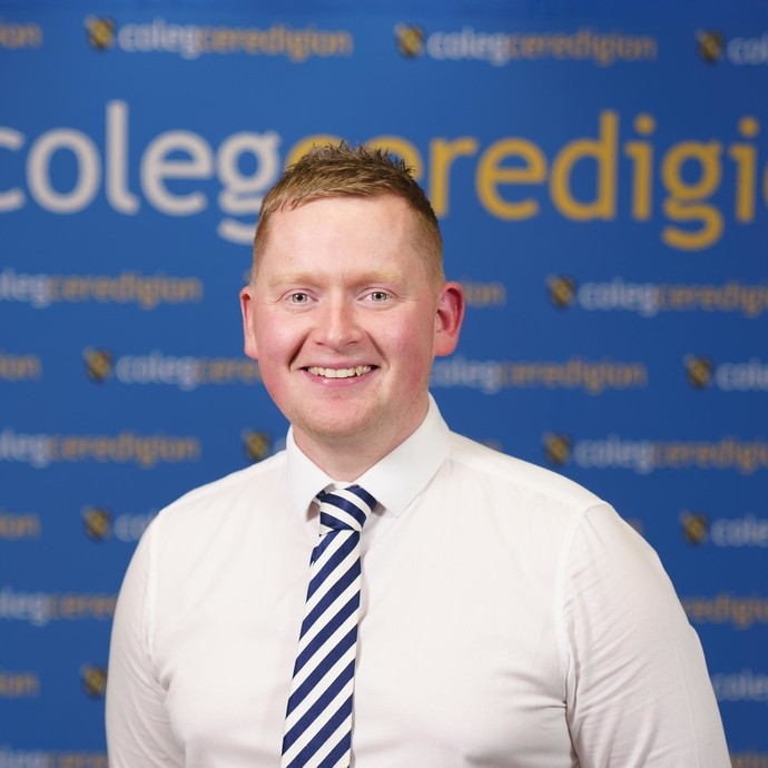 Rhodri in a shirt and tie looking at the camera