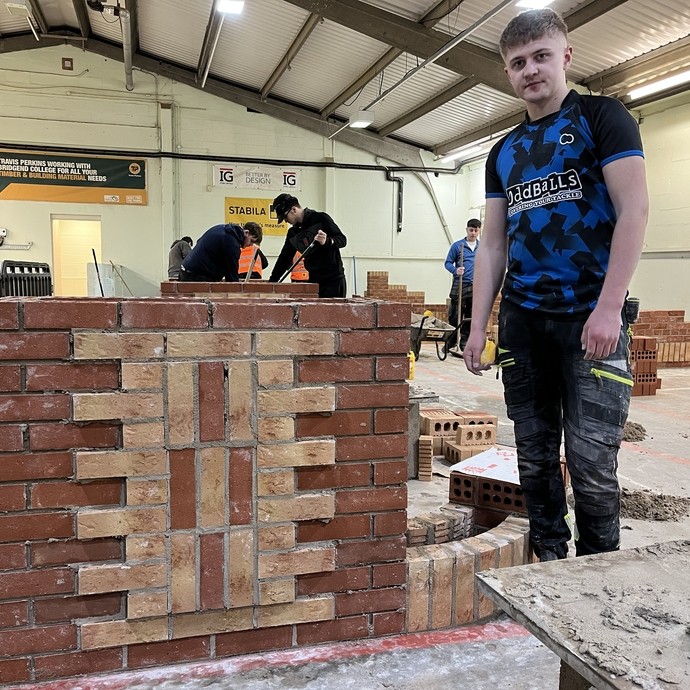 The winner of third place standing in the competition workshop with his finished brickwork